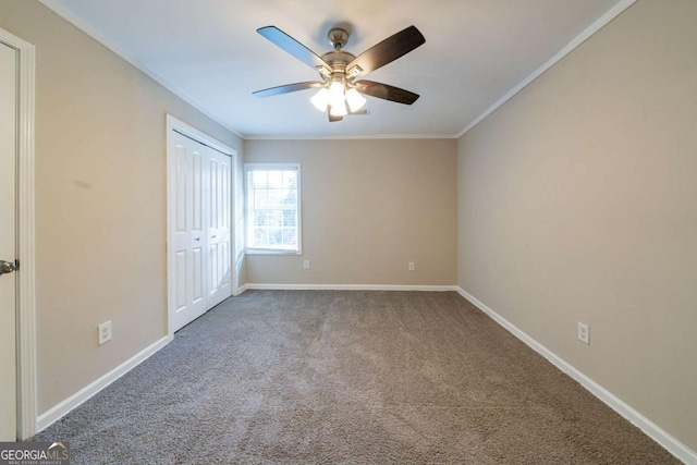 unfurnished bedroom with crown molding, carpet, ceiling fan, and a closet