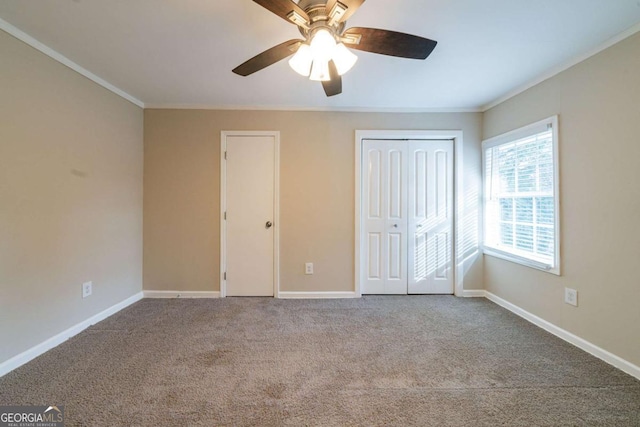 unfurnished bedroom with crown molding, ceiling fan, and carpet