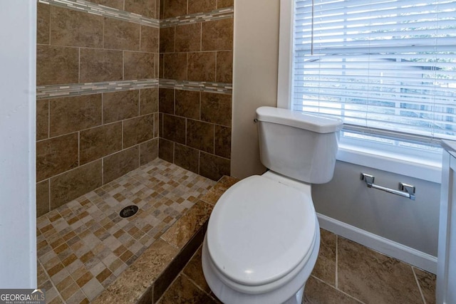 bathroom with toilet and a tile shower