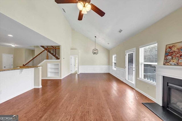 unfurnished living room featuring lofted ceiling, dark wood-type flooring, and ceiling fan