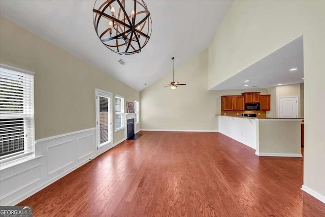 unfurnished living room featuring high vaulted ceiling, dark hardwood / wood-style floors, and ceiling fan