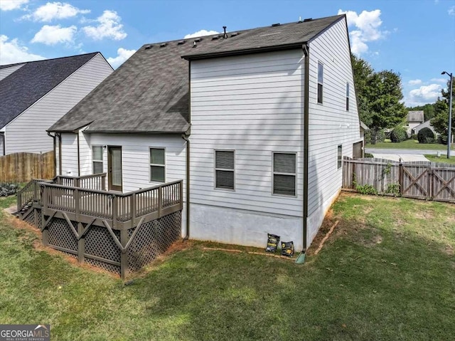 rear view of property with a lawn and a deck