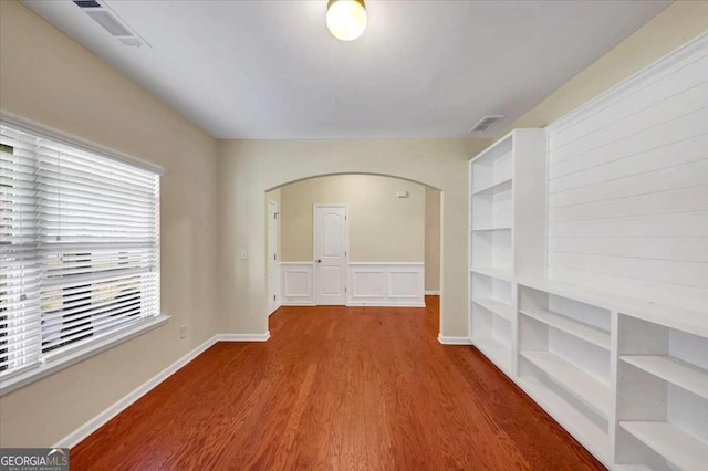 spare room featuring hardwood / wood-style floors and built in features