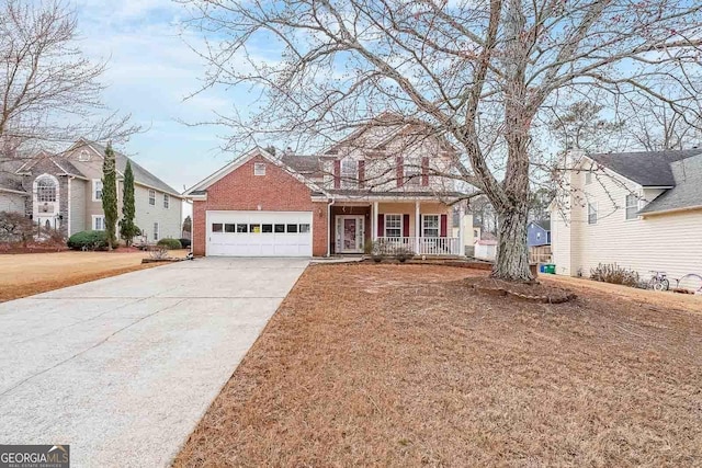 view of front facade featuring a porch, a garage, and a front lawn