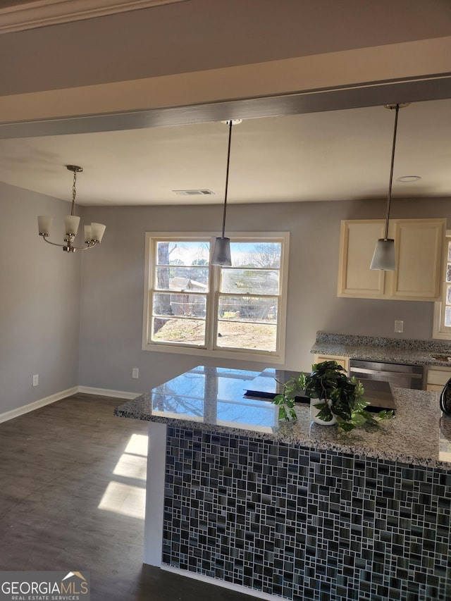 kitchen with dark hardwood / wood-style floors, light stone counters, decorative light fixtures, stainless steel dishwasher, and a chandelier