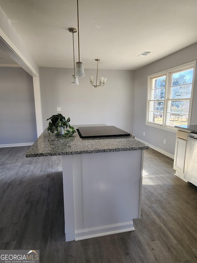 kitchen with pendant lighting, dishwasher, an inviting chandelier, dark hardwood / wood-style floors, and light stone counters