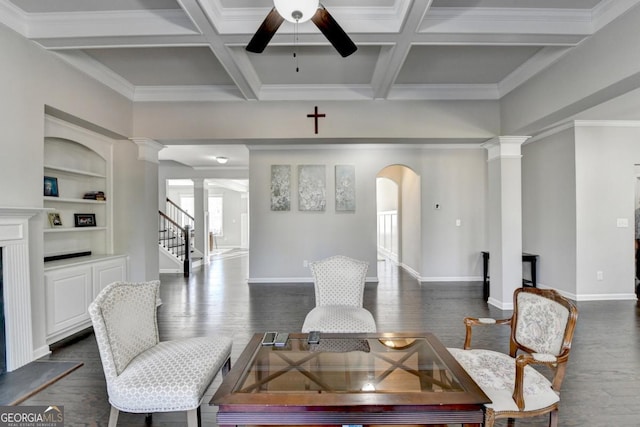 living room with decorative columns, beamed ceiling, ceiling fan, dark wood-type flooring, and built in shelves