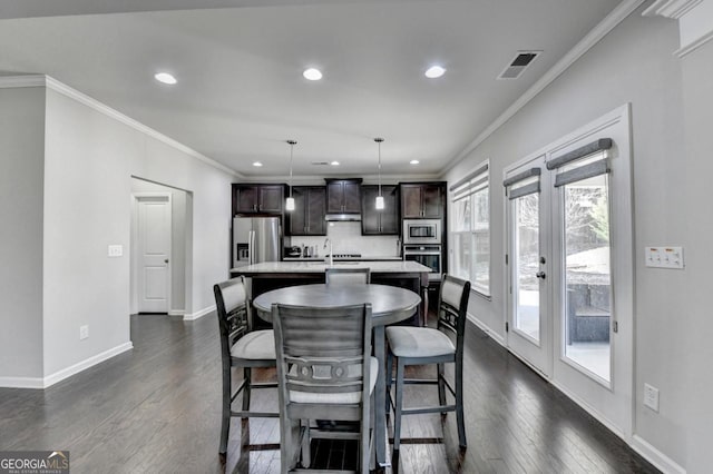 dining room featuring crown molding and dark hardwood / wood-style flooring