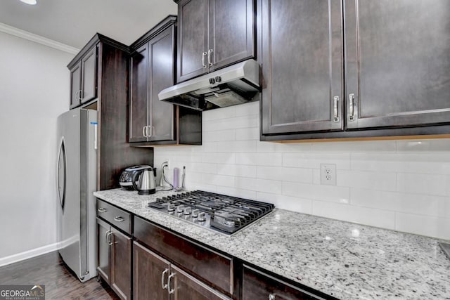 kitchen with backsplash, stainless steel appliances, light stone countertops, ornamental molding, and dark hardwood / wood-style flooring