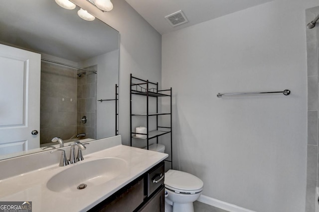 full bathroom with tiled shower / bath, vanity, and toilet