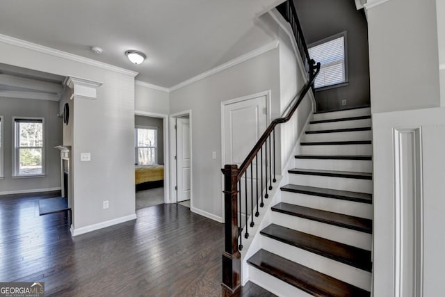 entryway featuring crown molding, dark wood-type flooring, and a healthy amount of sunlight