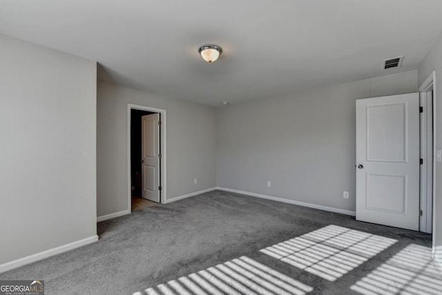 spare room featuring dark colored carpet