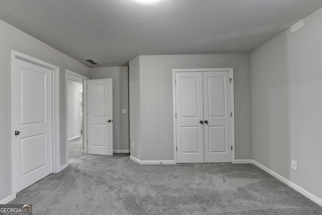 unfurnished bedroom featuring light colored carpet and a closet