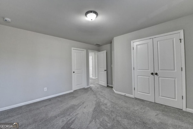 unfurnished bedroom with light carpet and a closet