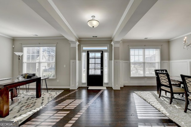 entryway featuring crown molding, dark wood-type flooring, and ornate columns