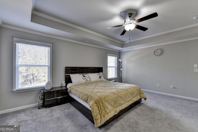 carpeted bedroom featuring ornamental molding, a raised ceiling, and ceiling fan