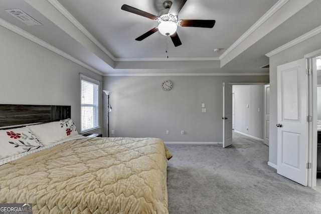 carpeted bedroom with ornamental molding, ceiling fan, and a tray ceiling