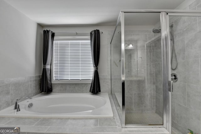 bathroom featuring a wealth of natural light and shower with separate bathtub