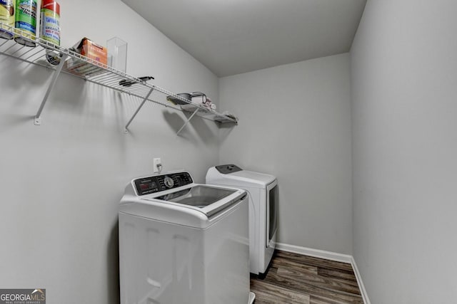 laundry area featuring washing machine and clothes dryer and dark hardwood / wood-style flooring