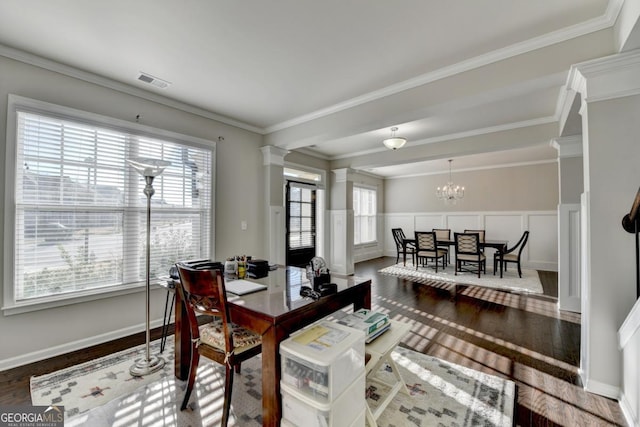 dining area featuring decorative columns, wood-type flooring, ornamental molding, and an inviting chandelier