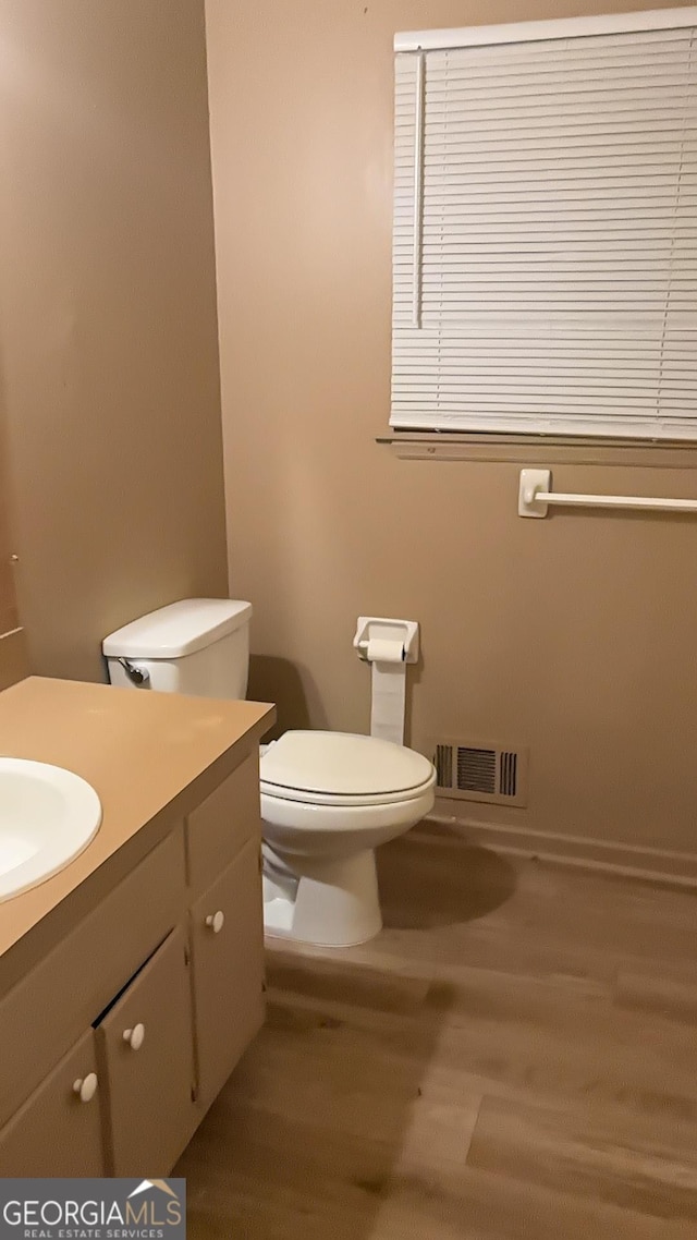 bathroom with vanity, toilet, and wood-type flooring