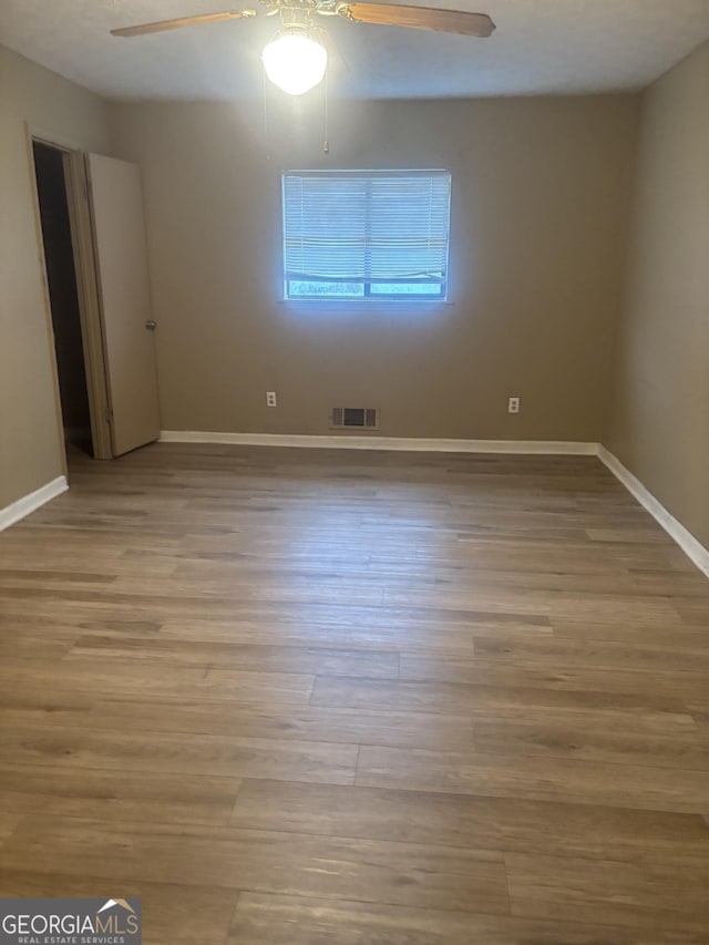 empty room featuring ceiling fan and light wood-type flooring