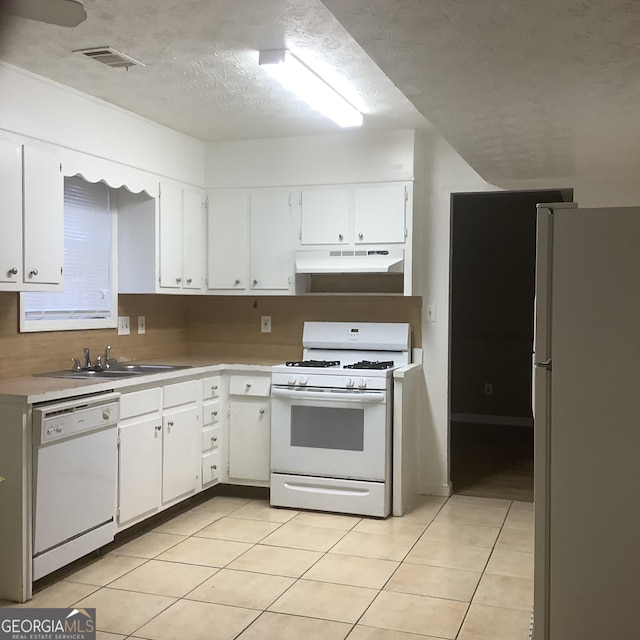 kitchen with white cabinetry, sink, white appliances, and light tile patterned floors