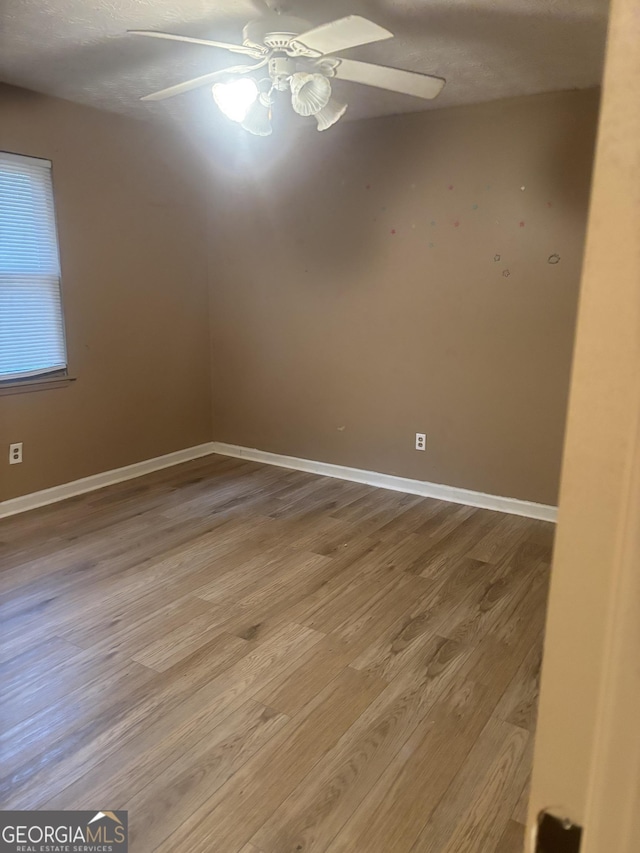 spare room with wood-type flooring and ceiling fan