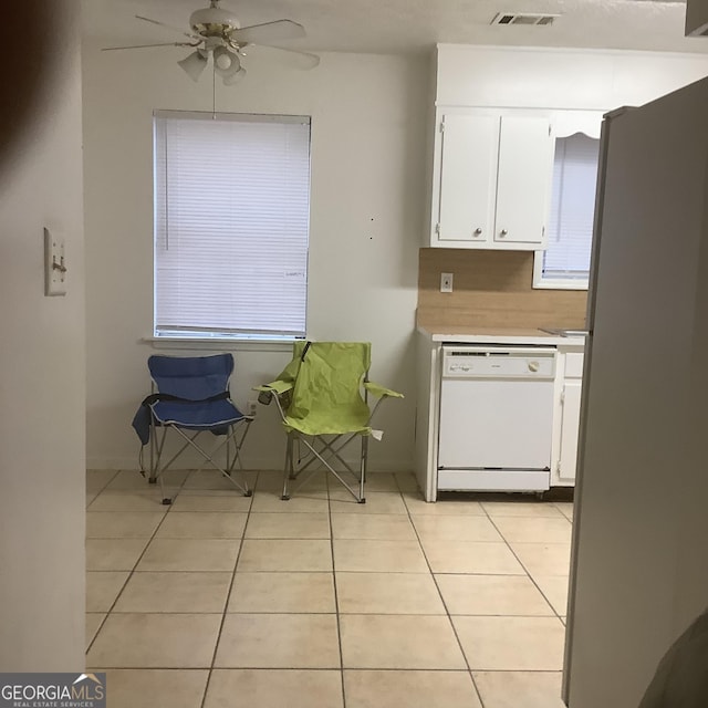 kitchen featuring light tile patterned flooring, stainless steel refrigerator, white dishwasher, ceiling fan, and white cabinets