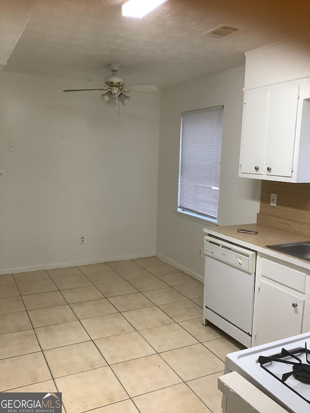 kitchen featuring dishwasher, sink, white cabinets, light tile patterned floors, and ceiling fan