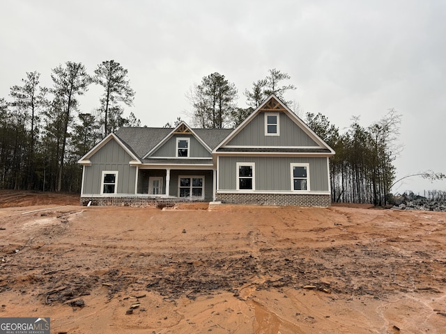 craftsman-style home featuring brick siding, covered porch, and board and batten siding