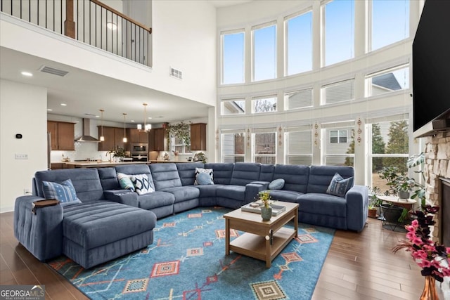 living room featuring dark hardwood / wood-style flooring and a stone fireplace