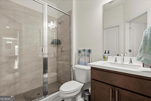 bathroom with vanity, a shower with shower door, and toilet