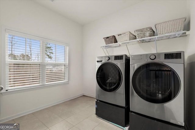 clothes washing area with light tile patterned flooring and washer and dryer