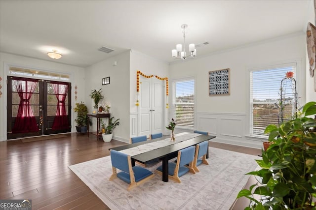 dining space featuring an inviting chandelier, dark hardwood / wood-style floors, and french doors