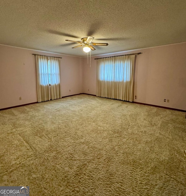 empty room with crown molding, carpet flooring, a textured ceiling, and ceiling fan