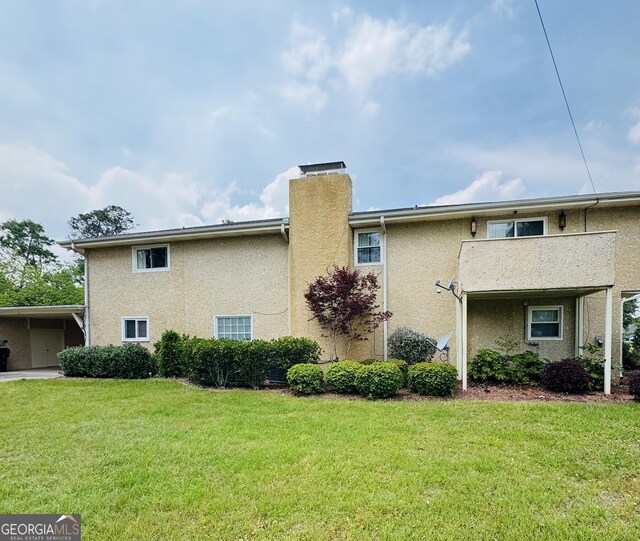 123 Blount St, Reidsville, GA 30453 - exterior space featuring a carport, a lawn, a chimney, and stucco siding