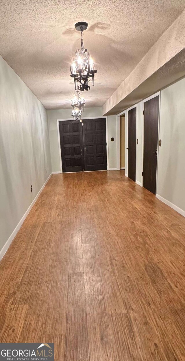 123 Blount St, Reidsville, GA 30453 - foyer featuring baseboards, wood finished floors, a textured ceiling, and an inviting chandelier