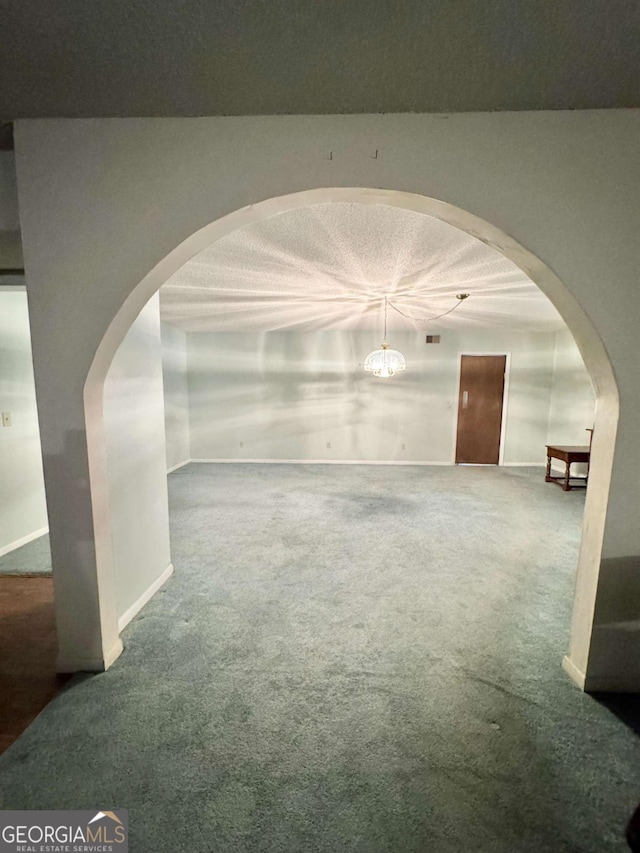 carpeted empty room featuring a textured ceiling