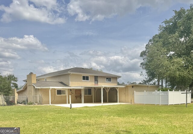 123 Blount St, Reidsville, GA 30453 - rear view of property featuring fence, a patio area, a yard, and stucco siding