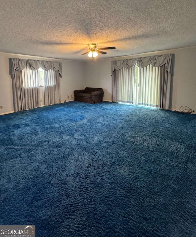 unfurnished room featuring ceiling fan, carpet floors, and a textured ceiling