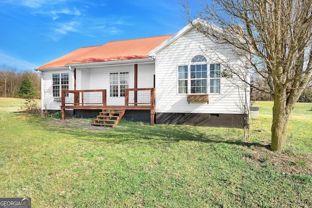 rear view of property featuring a wooden deck and a yard