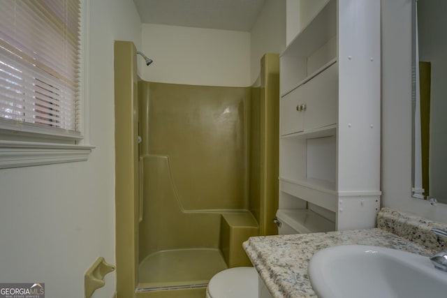 bathroom featuring vanity, toilet, and walk in shower