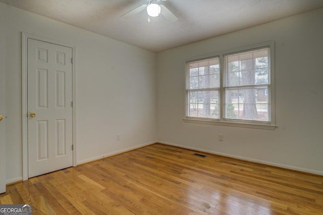 empty room with ceiling fan and light wood-type flooring