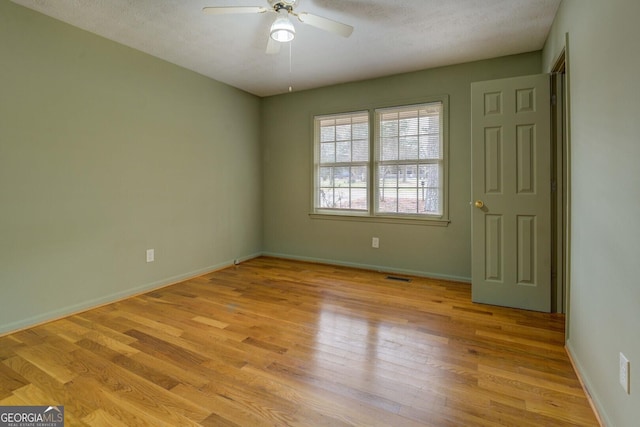 empty room featuring ceiling fan and light hardwood / wood-style floors