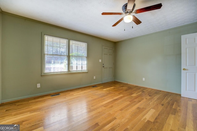 unfurnished room featuring ceiling fan, ornamental molding, a textured ceiling, and light wood-type flooring