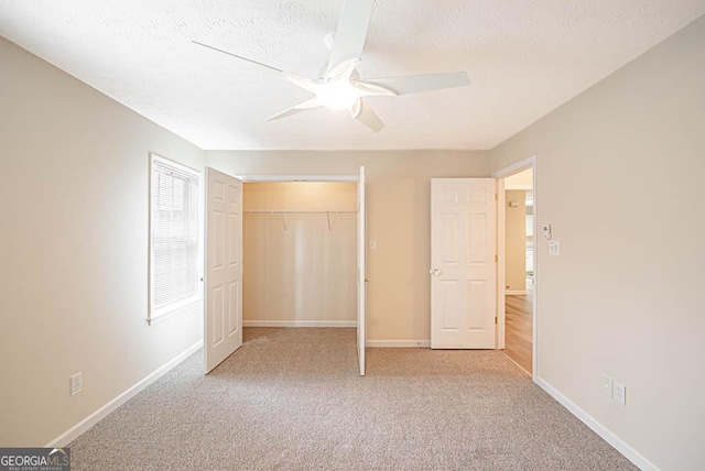 unfurnished bedroom featuring light carpet, a closet, and a textured ceiling