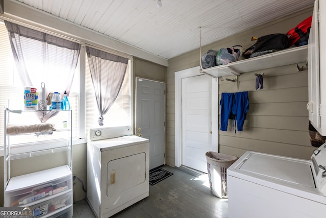 clothes washing area featuring wood finished floors, cabinet space, and separate washer and dryer