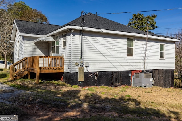 view of home's exterior with a shingled roof and cooling unit