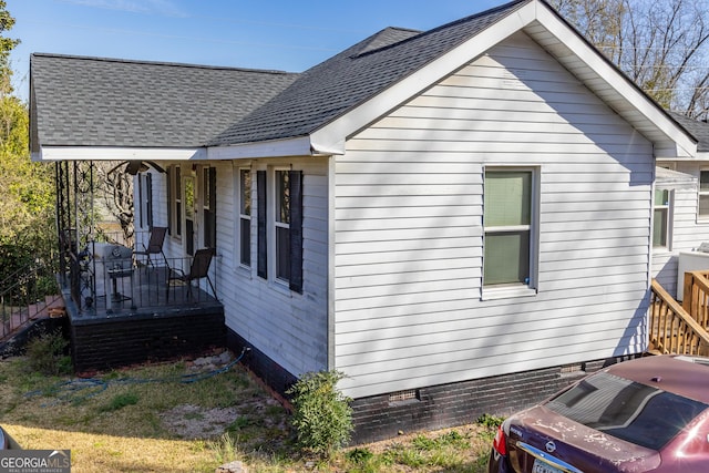 view of home's exterior featuring a shingled roof, crawl space, and covered porch